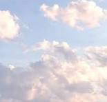 Cielo de un azul muy pálido, casi blanco, lleno de nubes. Las nubes son principalmente blancas, con toques de gris suave y reflejos de rosa pálido. Algunas nubes tienen bordes difusos y otras son más definidas. Sus formas varían: algunas son planas y extendidas, otras tienen una forma más abultada y algodonosa. El patrón general es disperso y no hay una formación dominante clara.